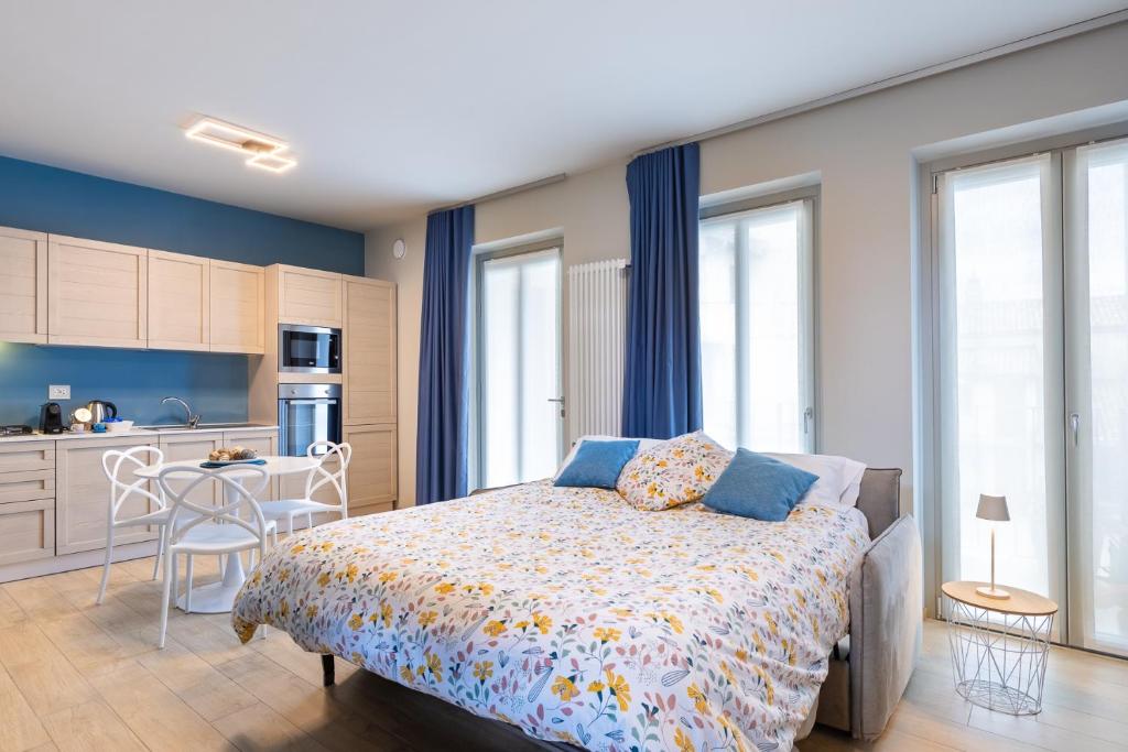 Cet appartement comprend une chambre avec un lit et une cuisine avec des fenêtres. dans l'établissement La Casa Nelle Aie - Appartamento Dolcetto - Private Parking - Free Wifi & AC, à La Morra