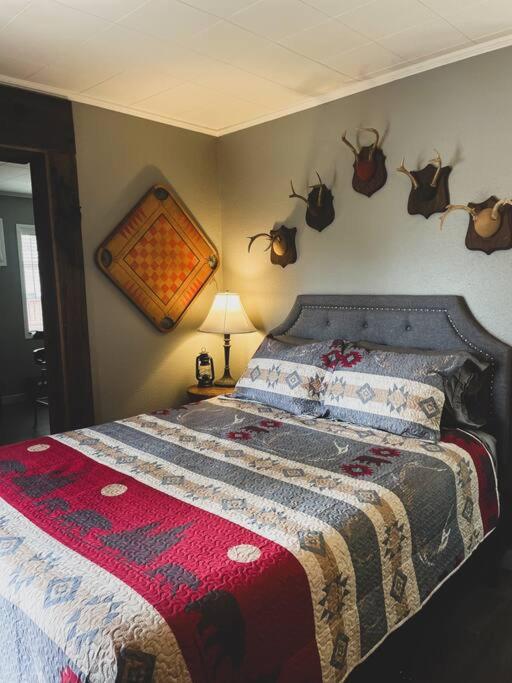 a bedroom with a bed with antlers on the wall at Deer Hollow Cottage at Tradewinds in Eureka Springs