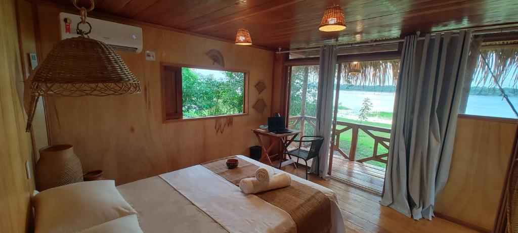 1 dormitorio con cama y ventana grande en Bioma EcoLodge, en Iranduba