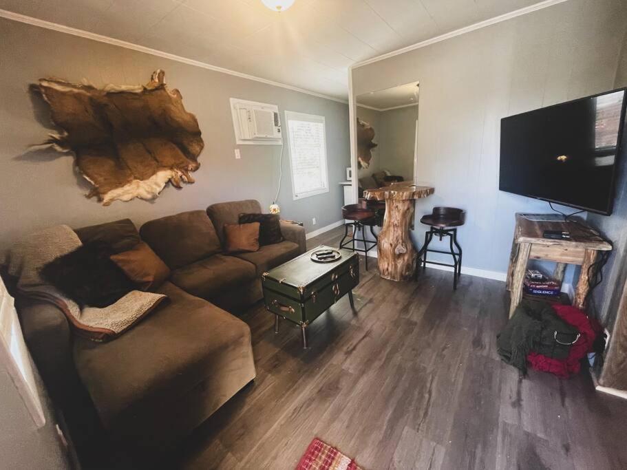 a living room with a couch and a flat screen tv at Deer Hollow Cottage at Tradewinds in Eureka Springs