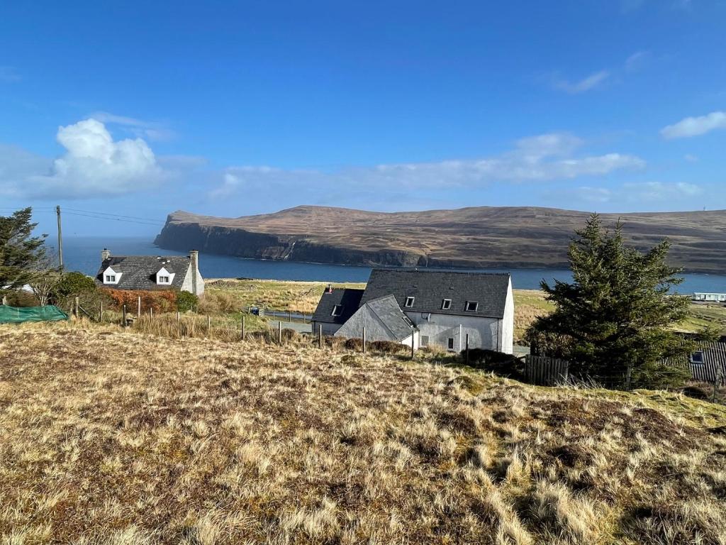 a group of houses on a hill with a body of water at Pooltiel View in Milovaig