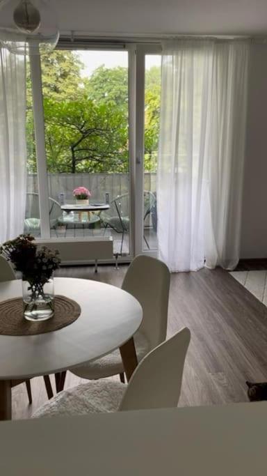 Hotel Zentrale, 55m2, helle 2 Zimmer Whg nähe Messe, a living room with a table and chairs and a large window at Zentrale, 55m2, helle 2 Zimmer Whg nähe Messe in Düsseldorf