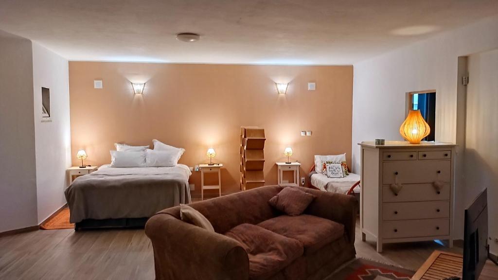 a living room with a couch and a bed at Studio Rocha Carvoeiro- Open Space in Carvoeiro