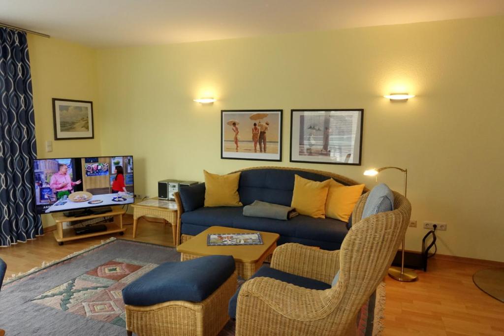 sala de estar con sofá azul y TV en Ferienwohnungen Fischerstieg Hafenblick en Timmendorf