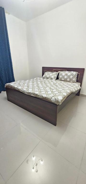 ein Bett mit einem Holzrahmen in einem Zimmer in der Unterkunft Luxury Private Room in Sharjah in Schardscha