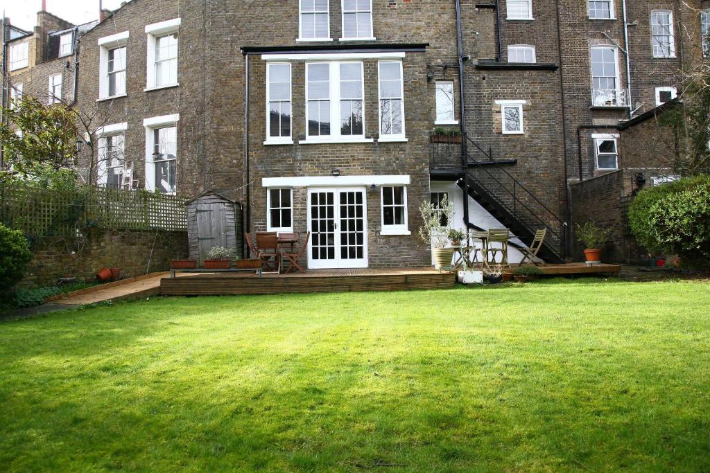 a large brick house with a lawn in front of it at Garden flat in a quiet Camden spot in London