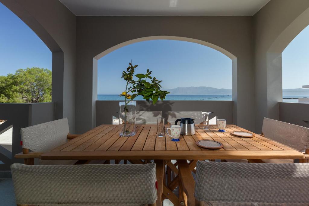a dining room with a wooden table and a large window at Zoe's Place - 2 BD Beachfront Apartment in Kissamos