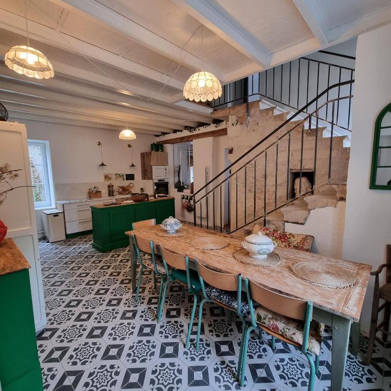 une salle à manger avec une table et un escalier dans l'établissement La Damoiselle en Bourgogne, à Ouanne