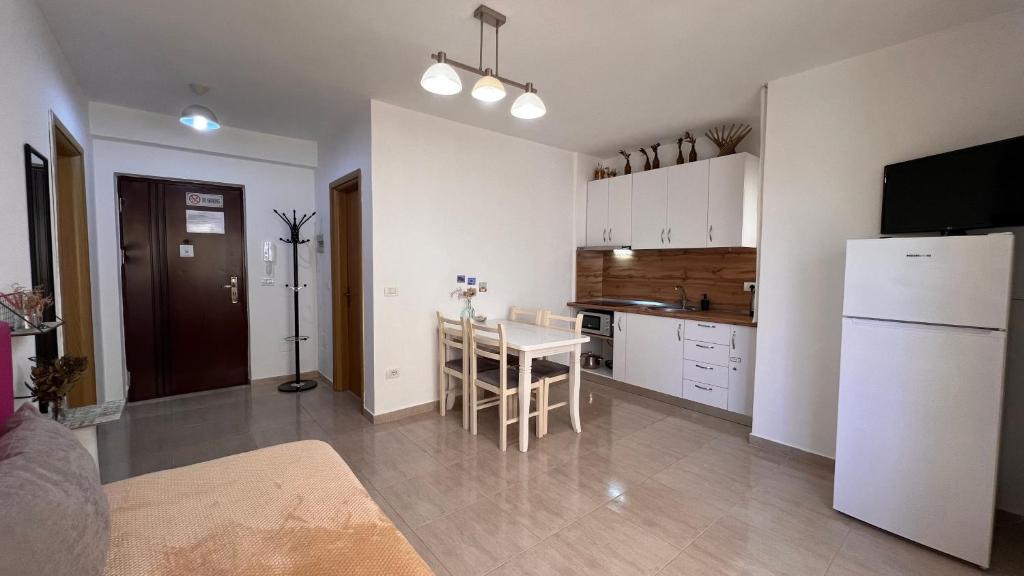 cocina con nevera blanca y mesa en Mire Apartment, en Durrës