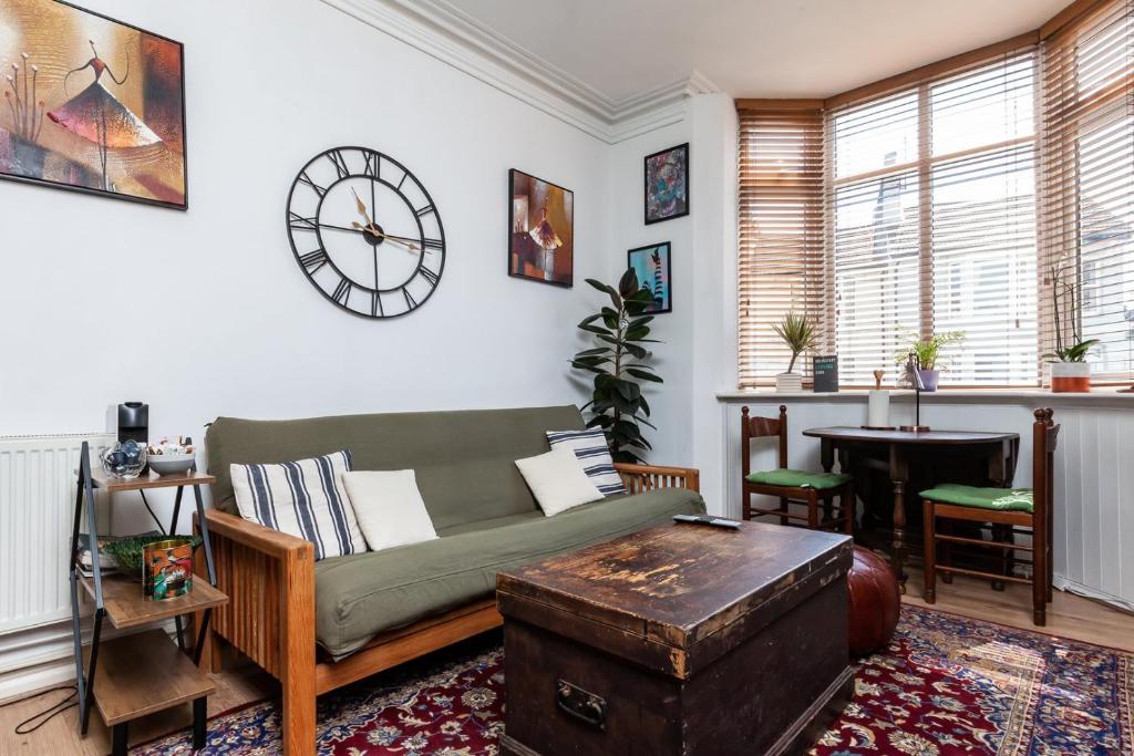 a living room with a couch and a clock on the wall at GuestReady - Interiores pitorescos em Brighton in Brighton & Hove