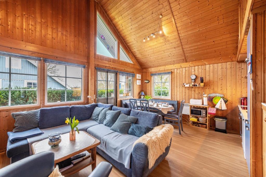 a living room with a blue couch and a table at Ferienhaus Sonnenblumen in Boltenhagen