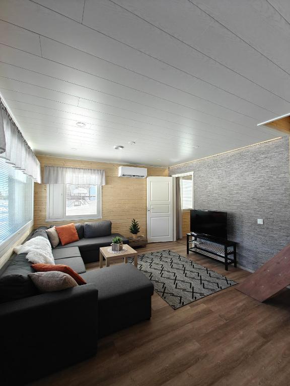 a living room with a couch and a television at Aava Sky Village in Aavasaksa