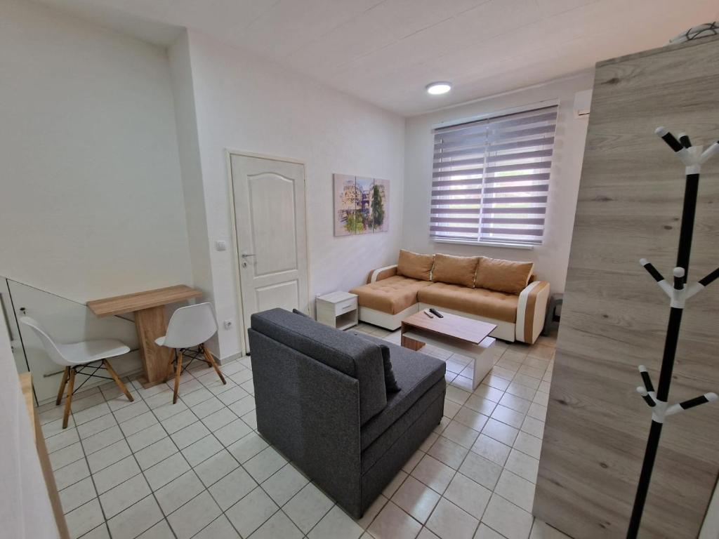 uma sala de estar com um sofá e uma mesa em Studio Petrovac B em Petrovac na Mlavi