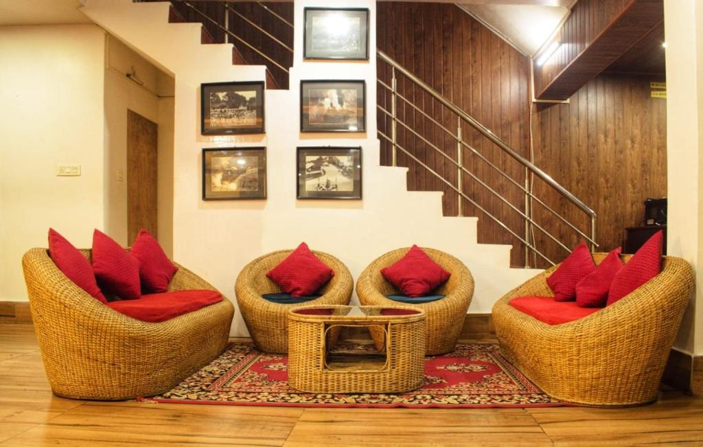 vestíbulo con sillas de mimbre y almohadas rojas en Hotel Comfort Residency en Darjeeling