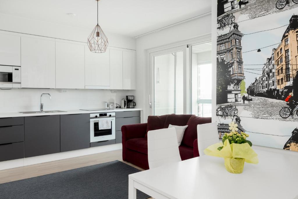 uma cozinha com armários brancos e uma mesa branca em New LUXUS 3BR Helsinki Home em Helsinque