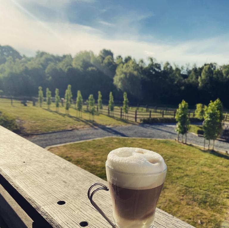 a cup of coffee sitting on top of a wooden table at Familie &amp; Vriendenwoning met fantastisch uitzicht in Ellezelles