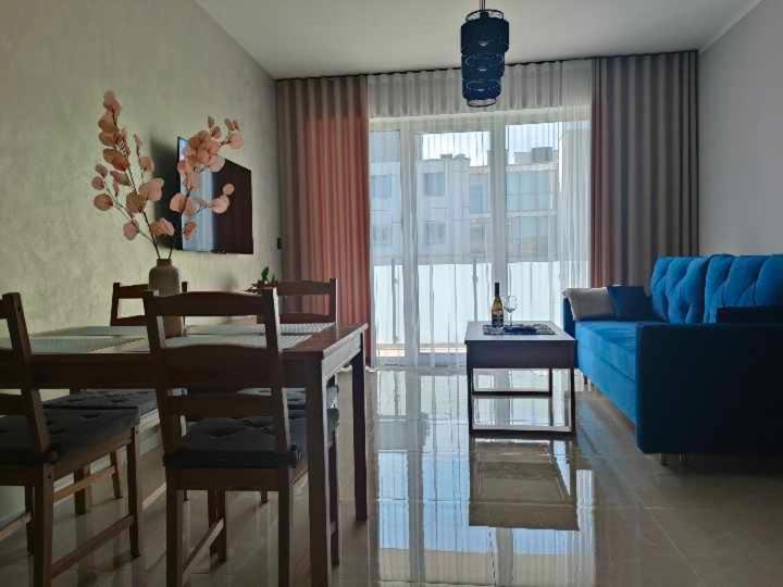 uma sala de estar com um sofá azul e uma mesa em Fox Apartament Free parking em Bolesławiec