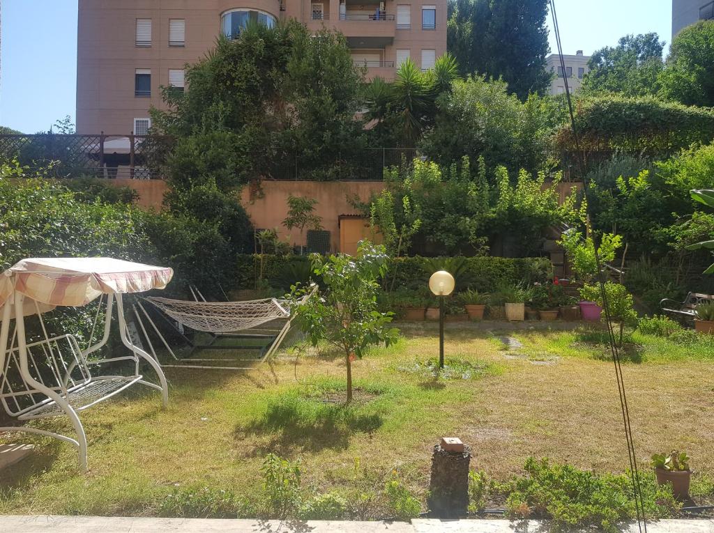 a garden with a hammock and trees and a building at EUR Charme Apt&GARDEN in Rome