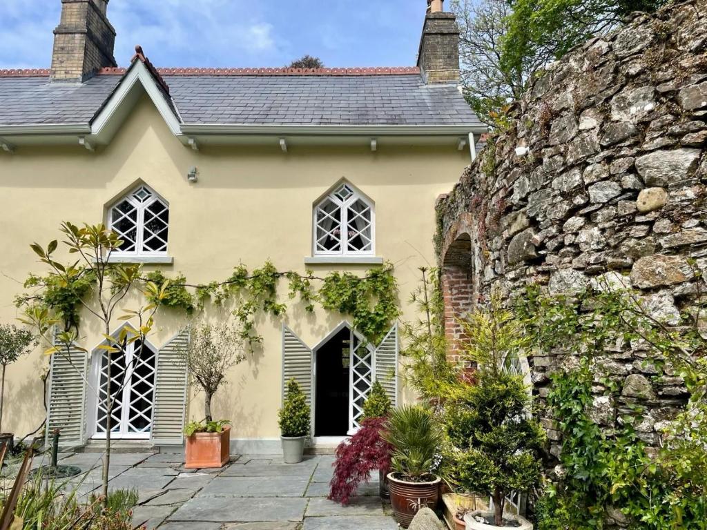 a yellow house with a stone wall at Chapel Annex in Bodmin