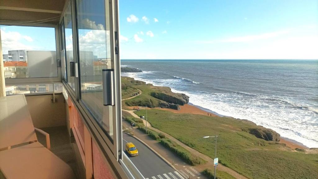 einen Blick aus einem Fenster auf eine Straße und das Meer in der Unterkunft Plein Sud magnifique vue 180 face mer in Les Bussolleries