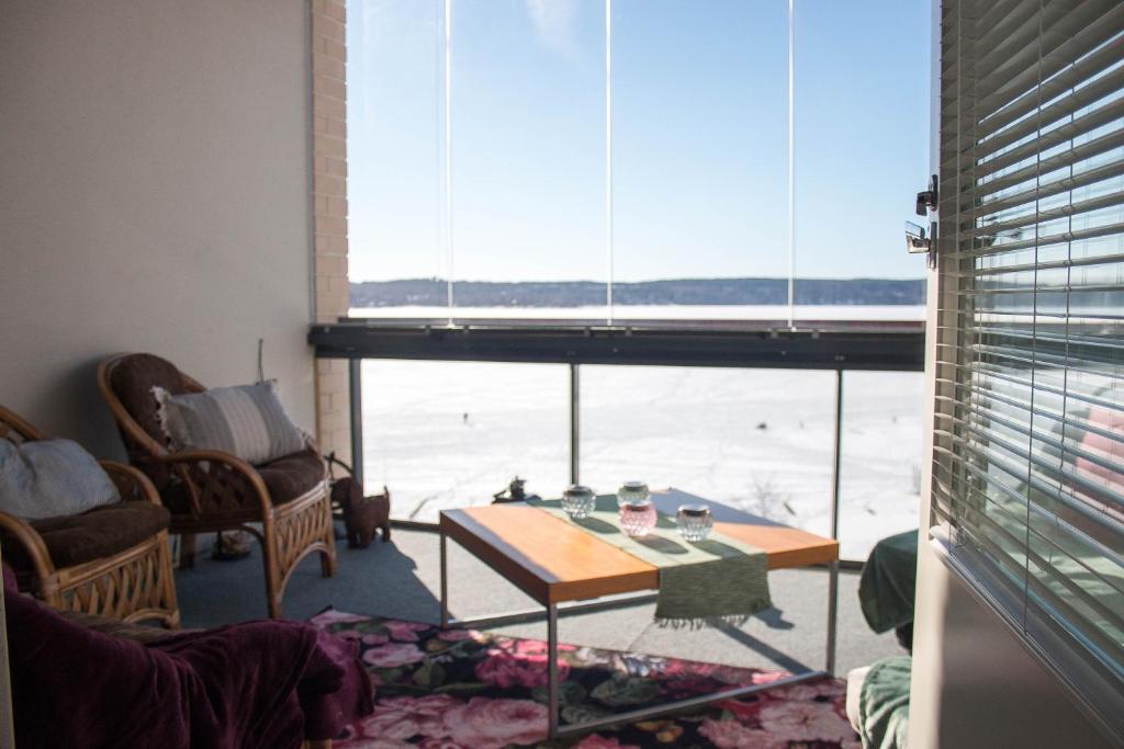 a living room with a table and a large window at Deluxe Apartment with Lake View and Sauna, Lahti in Lahti