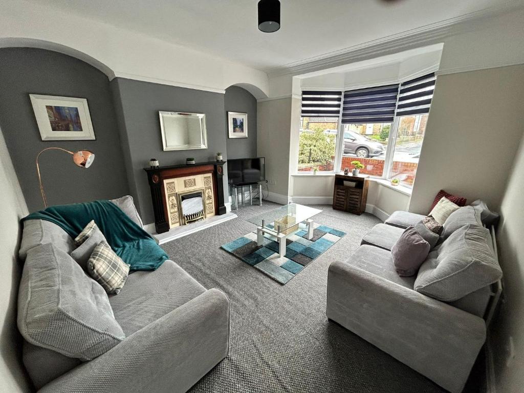 a living room with a couch and a fireplace at Huge 5 bed on the edge of Shildon in New Shildon