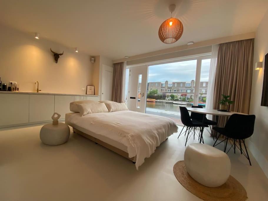 sypialnia z dużym łóżkiem, stołem i krzesłami w obiekcie Stads appartement w mieście Purmerend