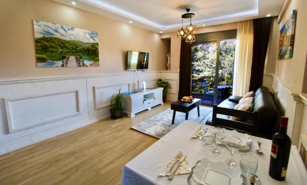 a living room with a table with wine glasses on it at Central Park Apartment in Tivat