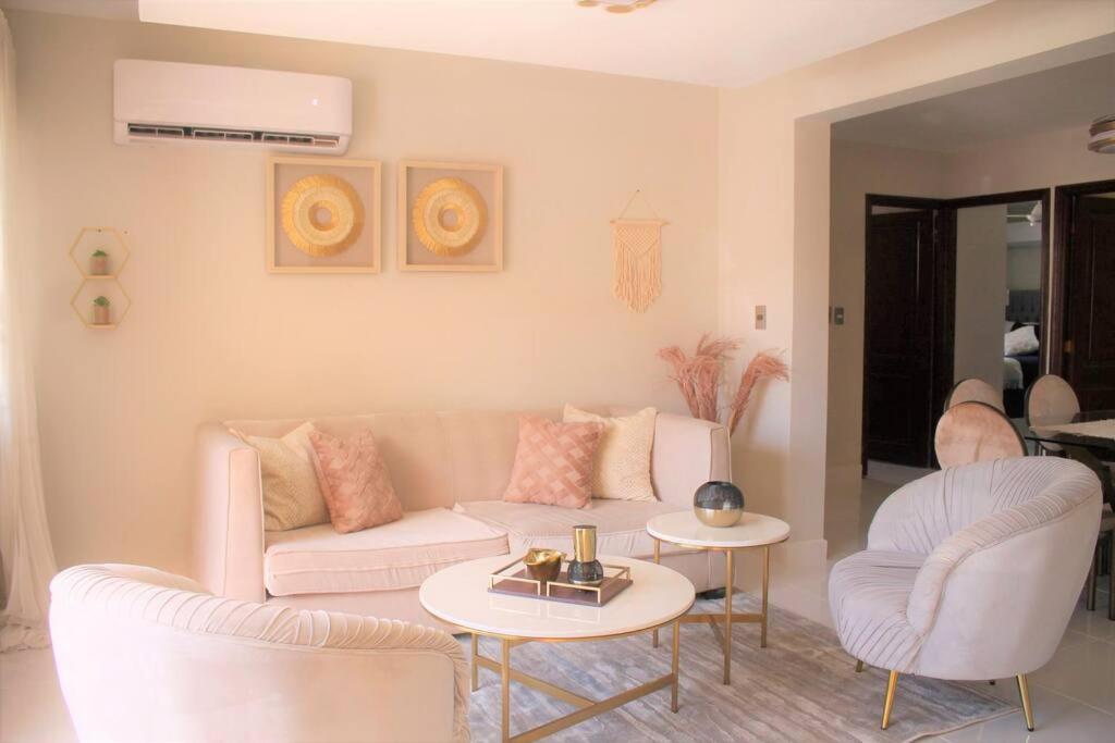 salon z dwoma białymi kanapami i dwoma stołami w obiekcie Apartamento Equipado, Wifi, AC, TV @drvacationsrental w mieście San Francisco de Macorís