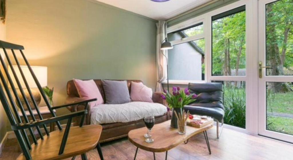 ein Wohnzimmer mit einem Sofa und einem Stuhl in der Unterkunft Painters Cottage 2-Bed Chalet nr St Ives & Hayle in St Ives