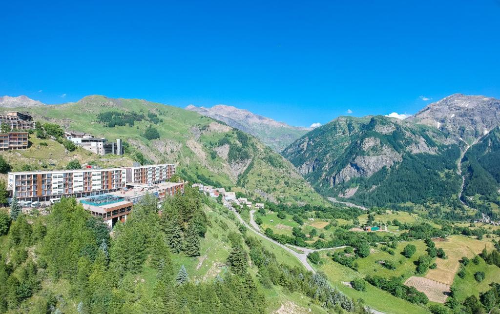 un hôtel sur une colline avec des montagnes en arrière-plan dans l'établissement Villages Clubs du Soleil - ORCIERES, à Orcières