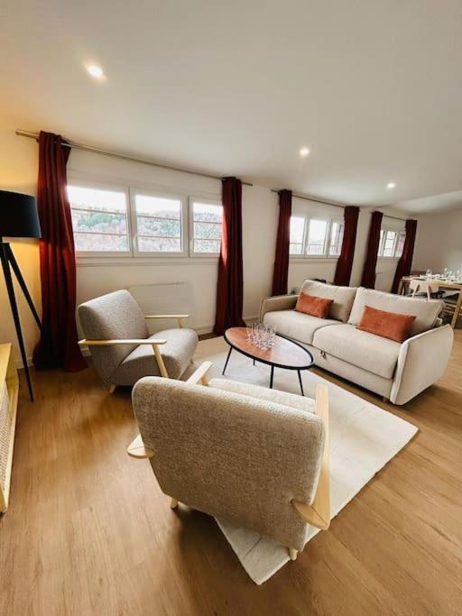 un salon avec des canapés, des chaises et une table dans l'établissement NEW : Appartement Vue montagne, à Mont-Dore