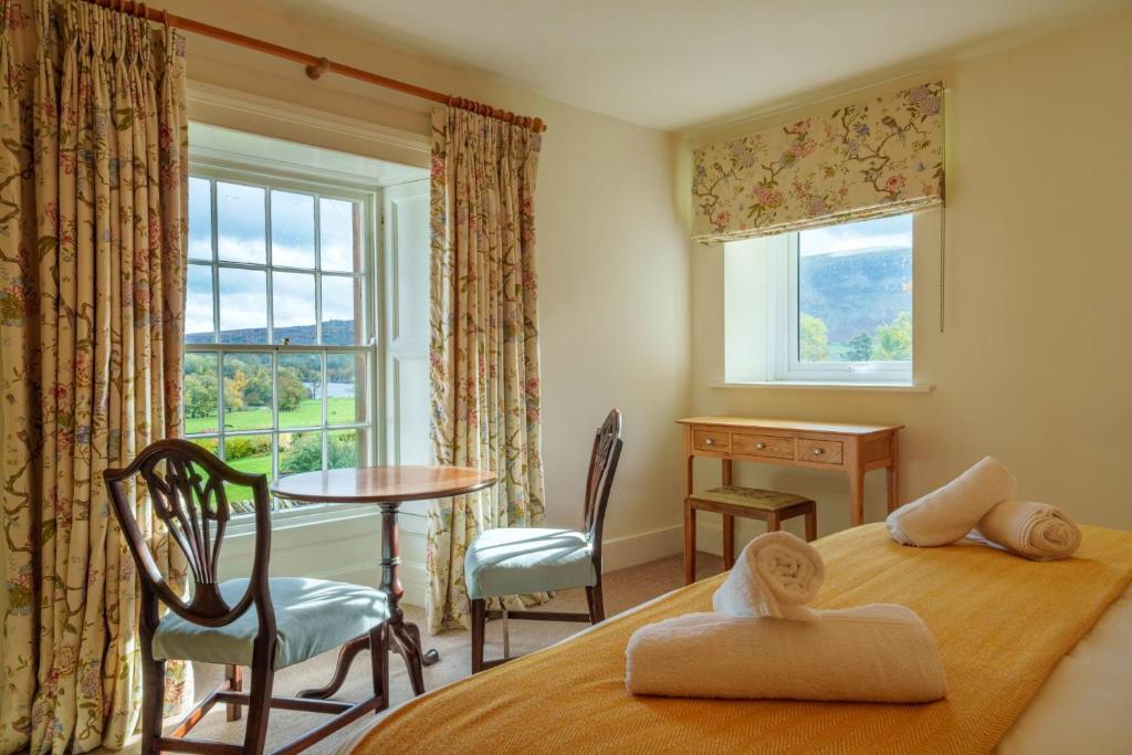 um quarto com uma cama, uma secretária e uma janela em Townend Farmhouse - Ullswater em Watermillock