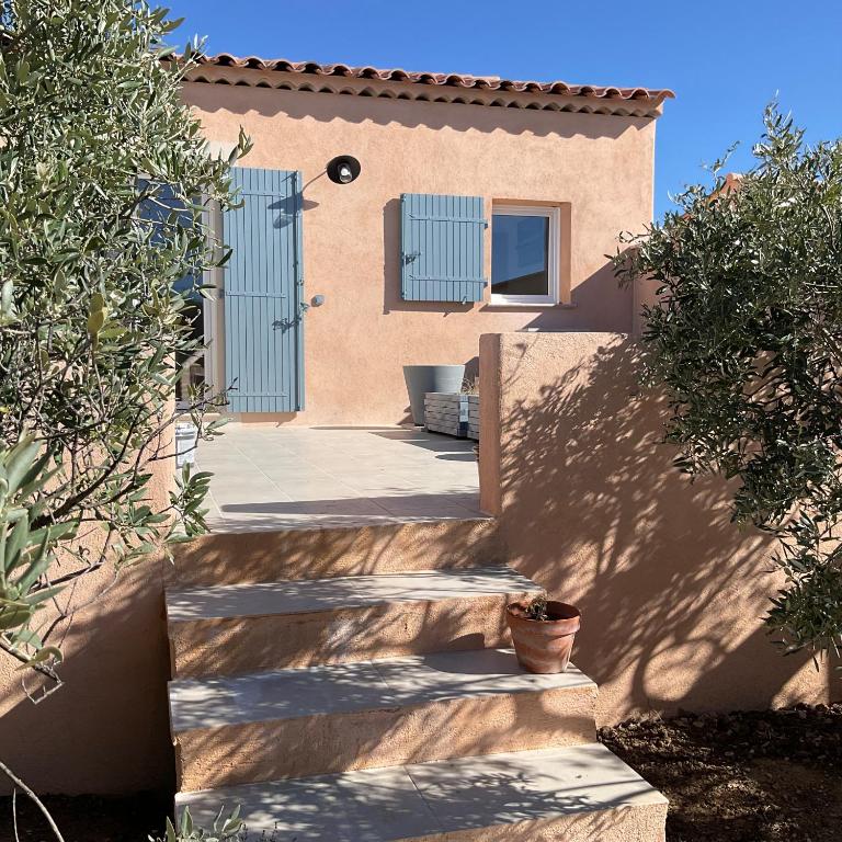 une maison avec une porte bleue et des escaliers à l'avant dans l'établissement La jasse, à Cabrières-dʼAigues