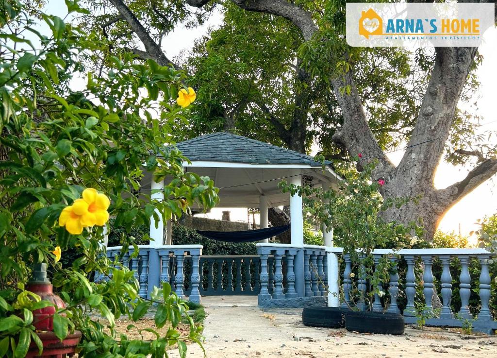 une clôture bleue avec un kiosque devant un arbre dans l'établissement ARNAS HOME, à San Andrés