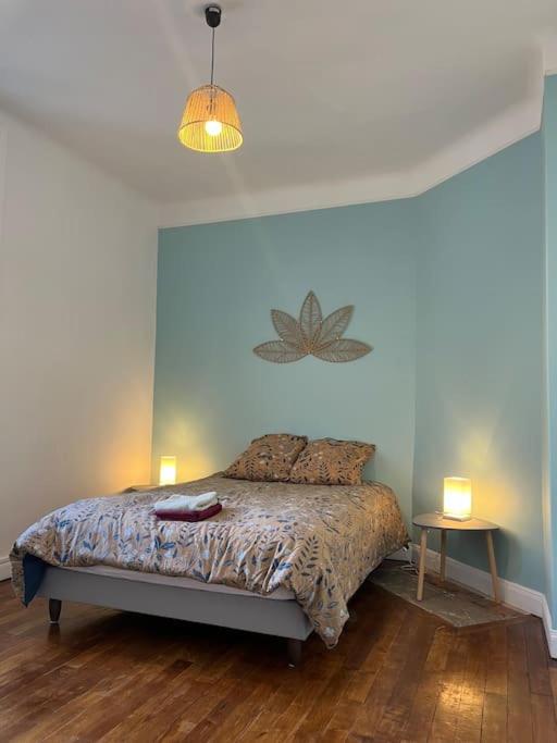 une chambre avec un lit avec deux lampes dessus dans l'établissement Appartement cœur de ville, à Soissons