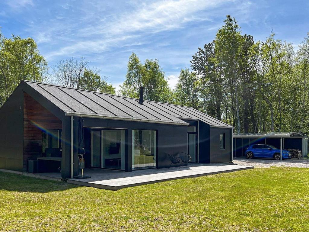 ein kleines schwarzes Haus auf einem Grasfeld in der Unterkunft 8 person holiday home in L s in Læsø