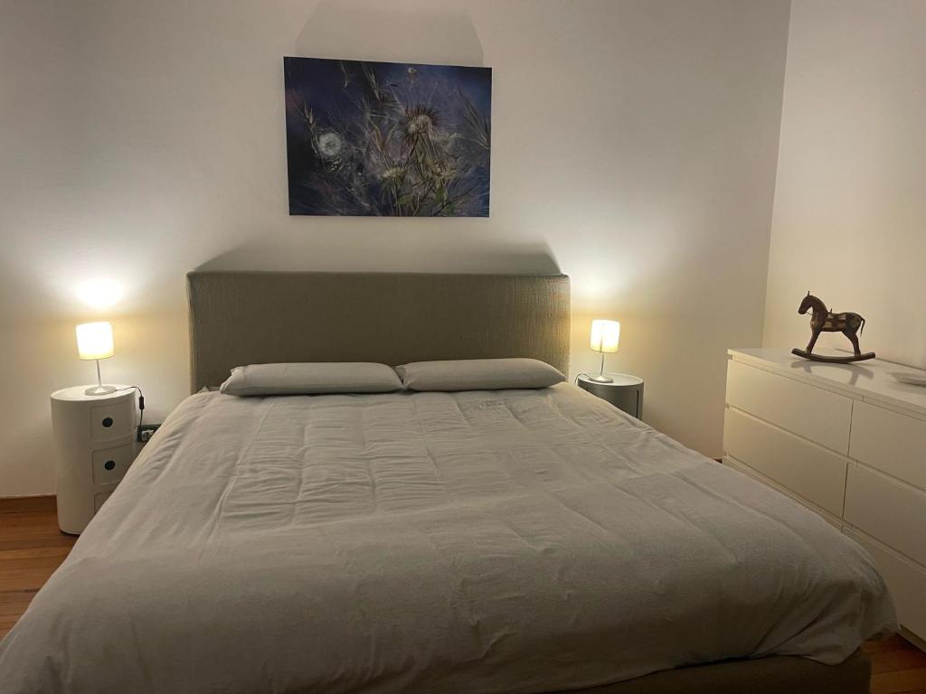 a bedroom with a large bed and two lamps at Appartamento centro storico in Via Palestro in Ivrea