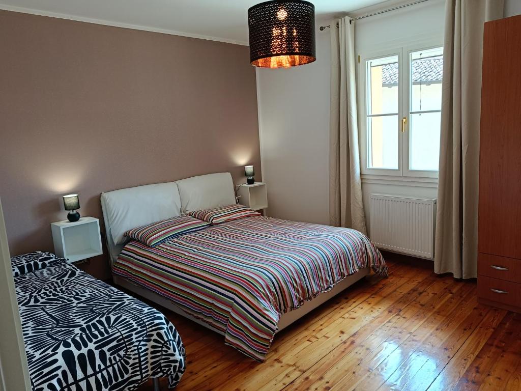 um quarto com uma cama e uma janela em Affittacamere La Loggia em Venzone