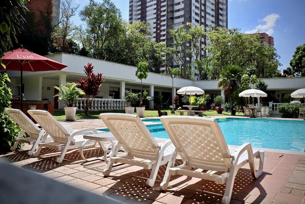 un gruppo di sedie e un tavolo accanto alla piscina di Casa campestre en poblado a Medellín