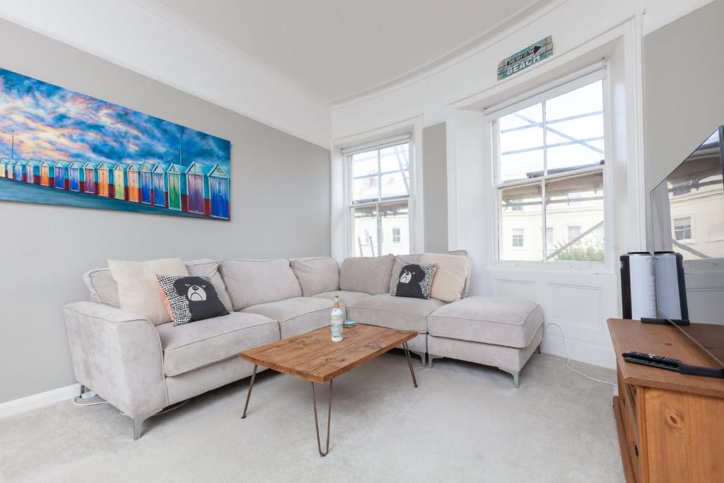 uma sala de estar com um sofá e uma mesa em GuestReady - Espaço maravilhoso em Brighton e Hove em Brighton & Hove