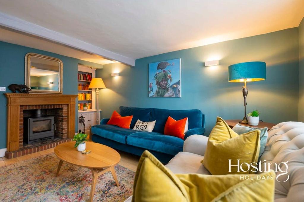 sala de estar con sofá azul y mesa en Spacious Luxury Cottage With Roof Terrace Close To The River Thames en Henley on Thames