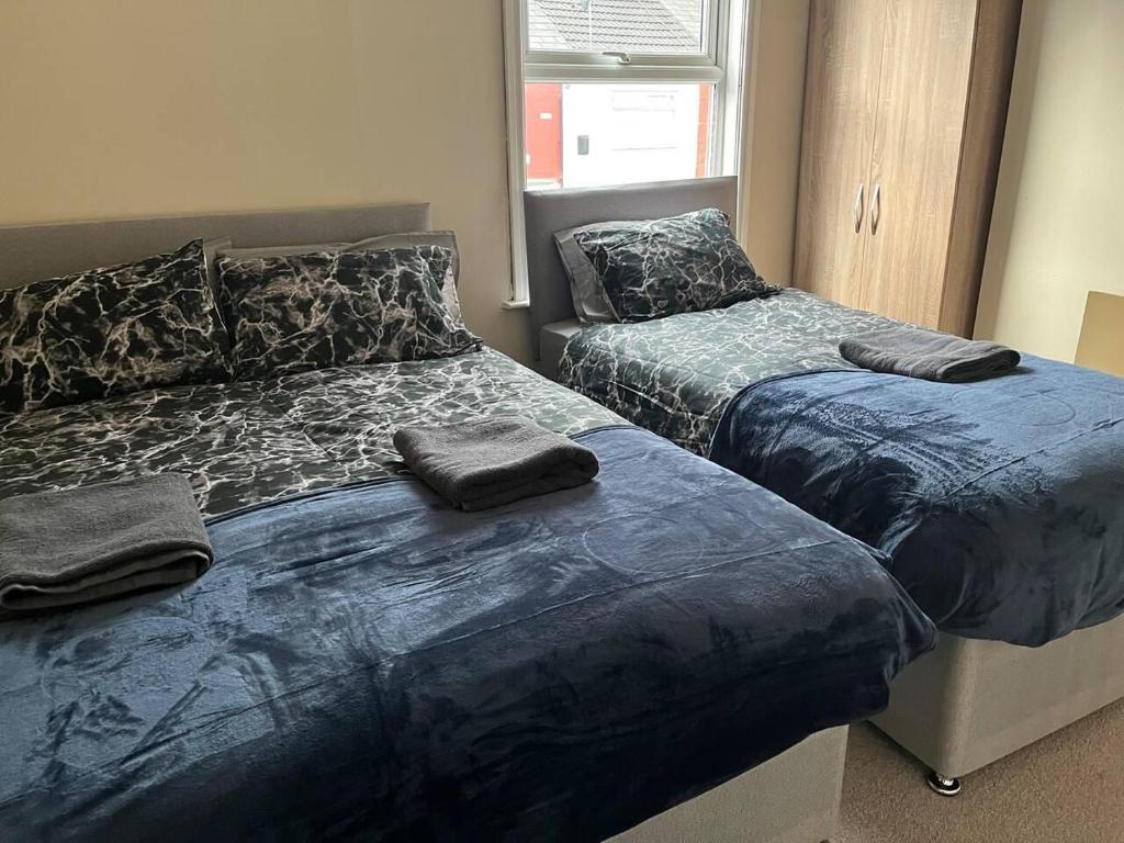 een slaapkamer met 2 bedden en een blauw dekbed bij Lovely 2-Bed House in Liverpool in Liverpool