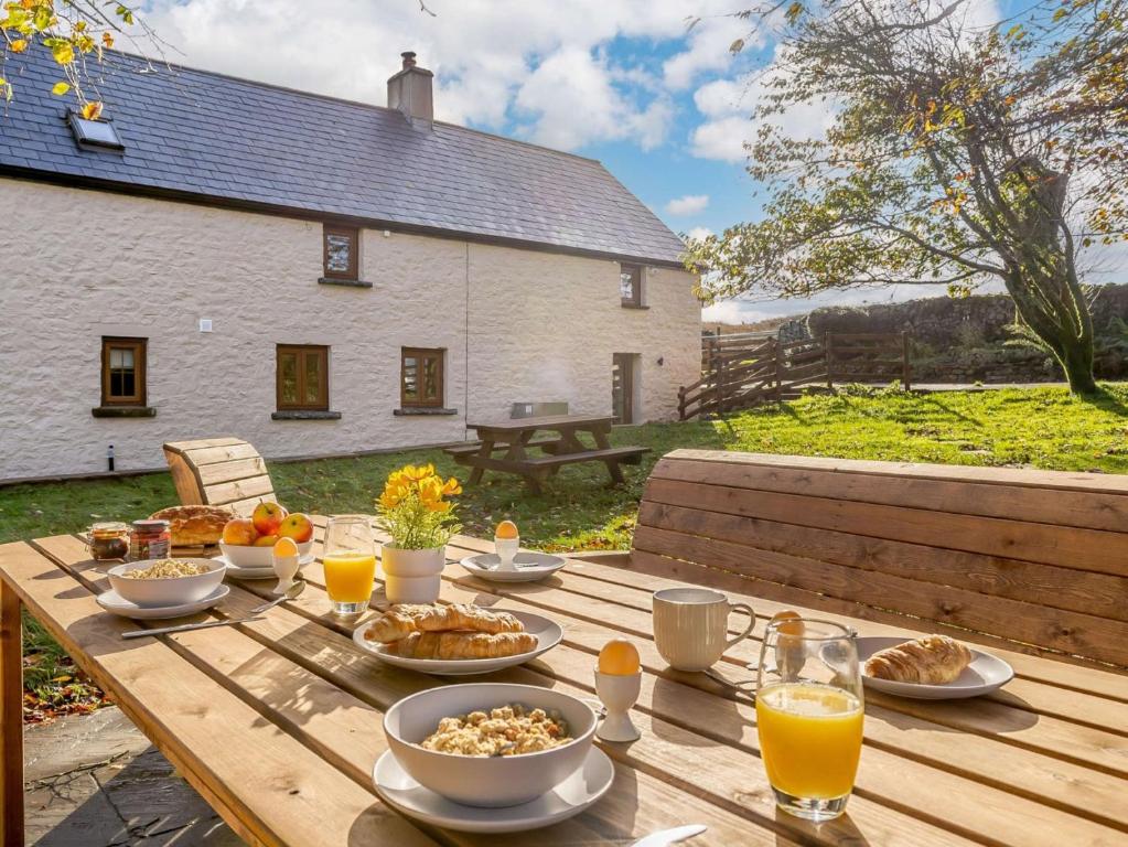a wooden table with food on it in front of a house at 4 Bed in Abergavenny 88014 in Llanover