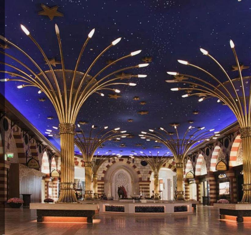 a shopping mall with palm trees on the ceiling at Premier Serviced Hostel in Dubai