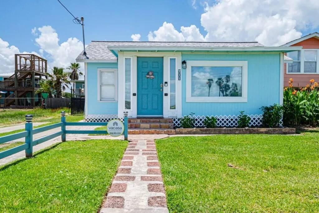 ein Haus mit einer blauen Tür und einem Rasenplatz in der Unterkunft The Cottage - Downtown Rockport in Rockport