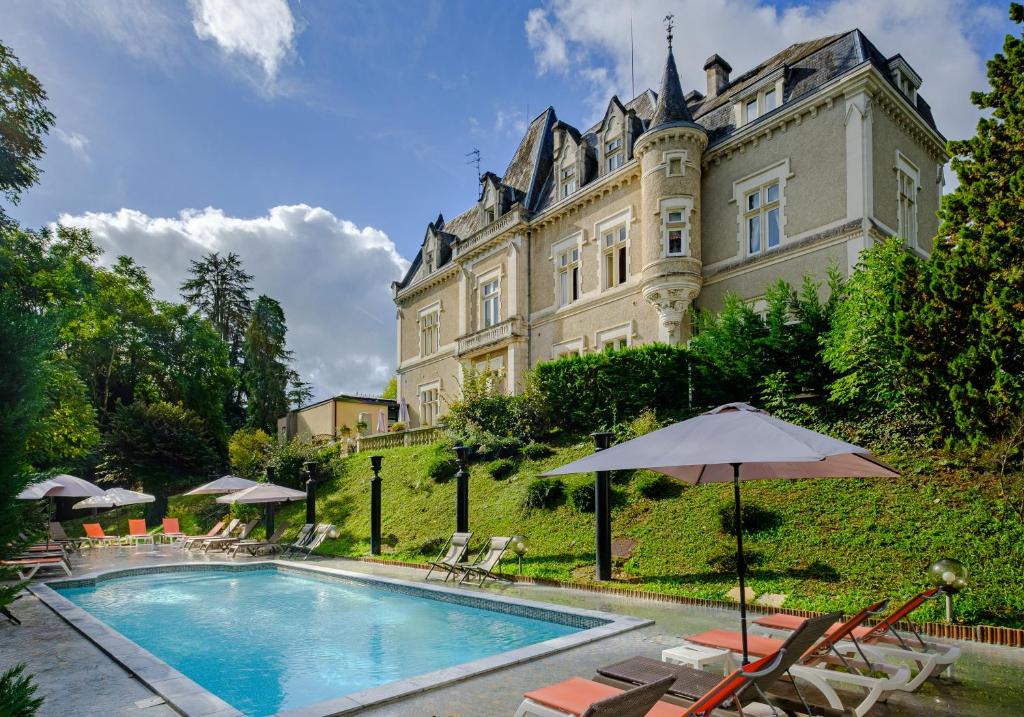 - un grand bâtiment avec une piscine en face dans l'établissement Château des Reynats, à Chancelade