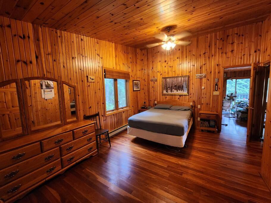 um quarto com uma cama e paredes e pisos em madeira em Private Rustic Lodge w/ Lakefront Views em Minden