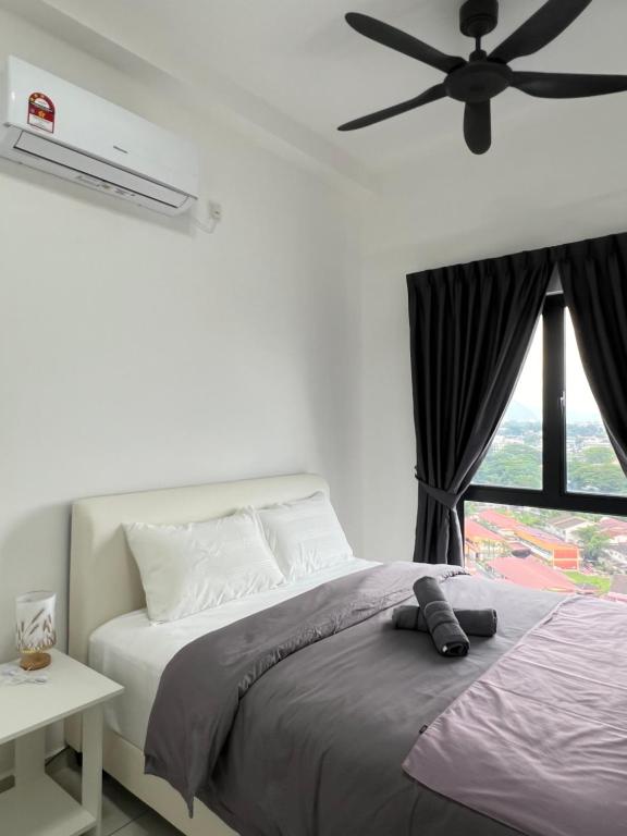 - une chambre avec un lit et un ventilateur de plafond dans l'établissement Blissful_Homestay2, à Ipoh