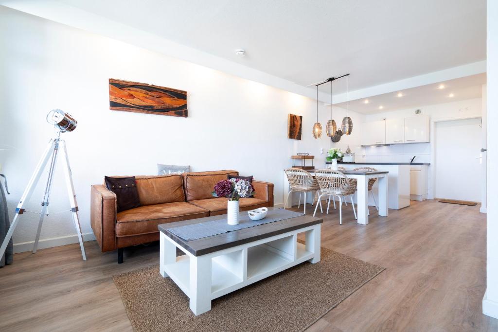 a living room with a couch and a table at Panoramic App A14-zehn in Sierksdorf